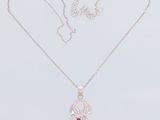 a white gold necklace with a red tear shaped pendant and a silver chain