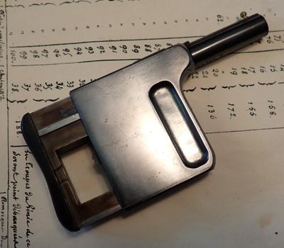 une pince métallique posée sur une feuille de papier