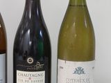 three bottles of wine are lined up on a white table