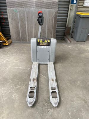 a forklift sitting in a warehouse with a fork on it