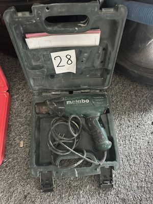 un outil qui se trouvait dans la mallette posée par terre, à côté d'une paire de chaussures