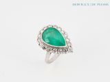 a close up of a ring with a green stone in it