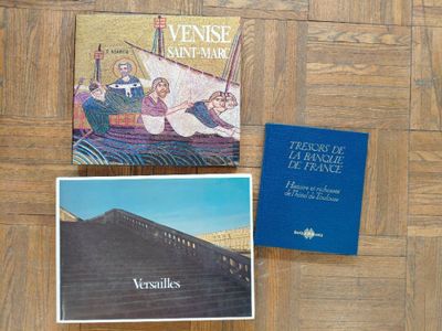 deux livres posés sur un plancher en bois, à côté d'un livre bleu