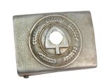 une image représentant une boucle de ceinture en métal argenté ornée d'un emblème circulaire