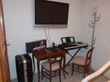 a desk with two chairs and a television on the wall