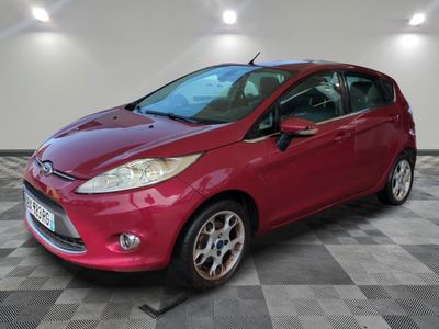 a red ford fiesta parked in a garage with a checkered floor