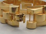gros plan d'un bracelet en or sur une table