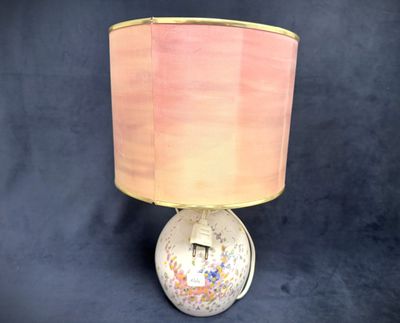 a lamp that has a pink shade on top of it