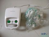 a white device with green buttons and a bag of plastic