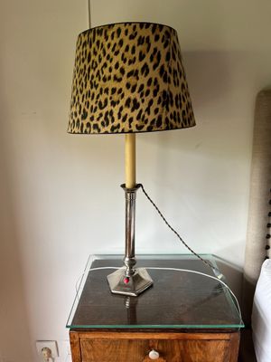 a lamp that is on top of a table next to a bed
