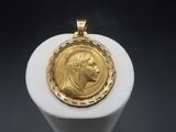 a close up of a gold coin on a white pedestal