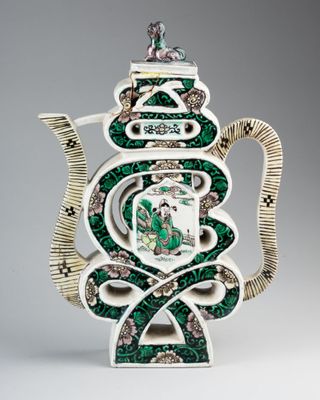 une image représentant une théière verte et blanche ornée d'un motif