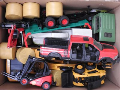 une boîte en carton remplie de petits véhicules et d'engins de chantier