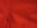 a close up of a red dress on a white surface