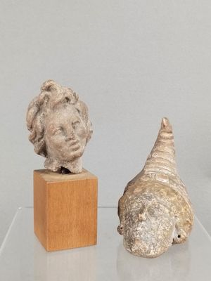 deux sculptures exposées sur une table en verre
