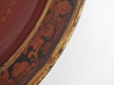 a close up of a red and gold plate on a table