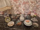 une table sur laquelle se trouvent une lampe, des vases et d'autres objets