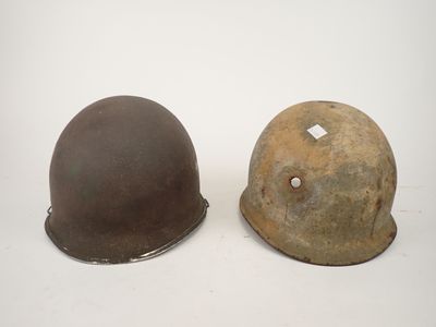 two helmets are sitting next to each other on a white surface