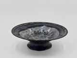 a blue and white bowl sitting on a black stand