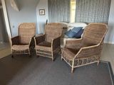 three wicker chairs in the corner of a room