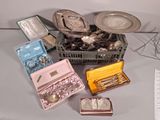 des couverts et d'autres objets en argent dans une boîte posée sur une table