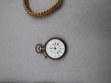 a watch and a gold chain on a table