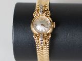 un gros plan d'une montre en or posée sur une bague noire
