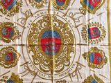 une écharpe blanche et dorée ornée d'emblèmes rouges et bleus