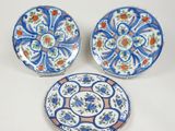 trois assiettes bleues et blanches ornées de fleurs, posées sur une table