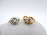 two gold and silver rings with diamonds on a white surface