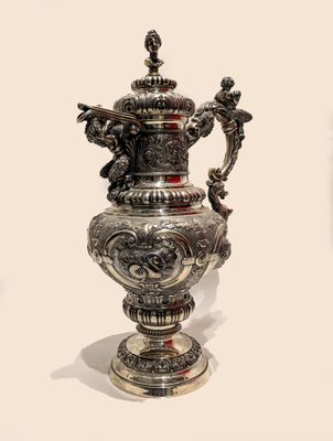 a silver vase that is sitting on a table