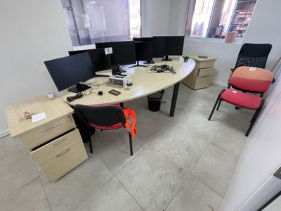 three computer screens on the desk in this office