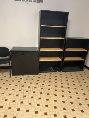 deux bibliothèques noires et deux chaises noires dans une pièce