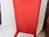 a red chair that is sitting on a white sheet