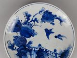 a blue and white plate with a bird and flowers on it