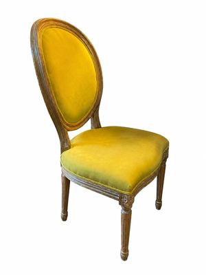 une image représentant une chaise en bois dont l'assise est recouverte d'un tissu jaune