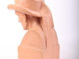 a clay head of a woman wearing a hat