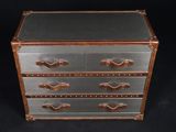 leather and metal chest of drawers on a black background