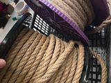 une corde enroulée autour d'un clavier d'ordinateur, sur lequel est posé un chapeau violet