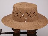 un chapeau de paille troué posé sur un support