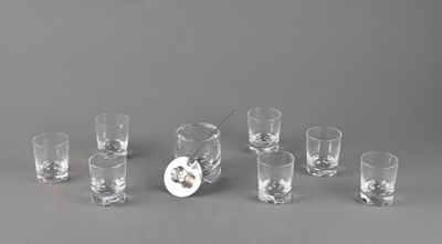plusieurs verres à shot et une carafe posés sur une table