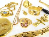 a lot of gold jewelry on a white surface