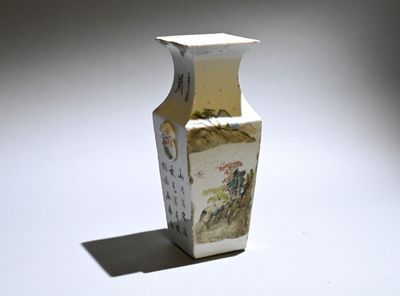 a white vase with a painting on it sitting on a table