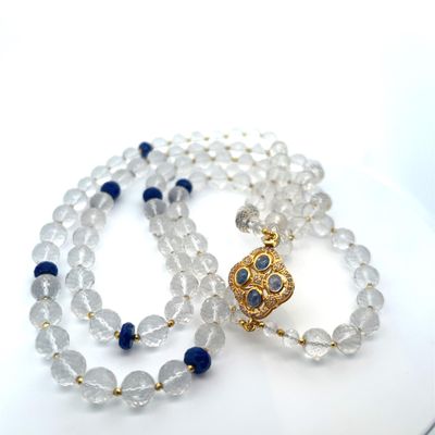un collier de perles blanches et bleues muni d'un fermoir doré