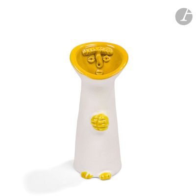 un vase jaune et blanc posé sur une surface blanche