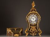 a gold clock sitting next to a box on a table
