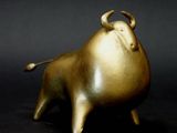 une figurine en or représentant un taureau sur fond noir