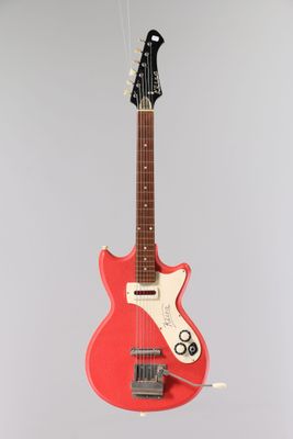 une guitare électrique suspendue à une corde fixée au mur