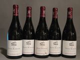 six bouteilles de vin rouge sont alignées sur une table