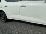 une photo d'une voiture blanche garée sur le bord de la route